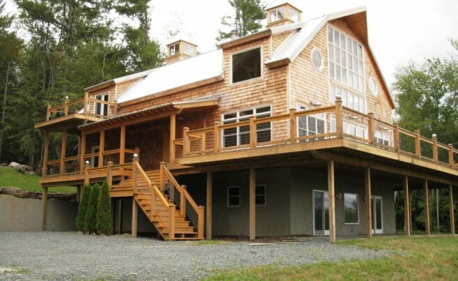 Exterior of Timber Frame Gambrel with Huge Windows and a Wrap Around Porch
