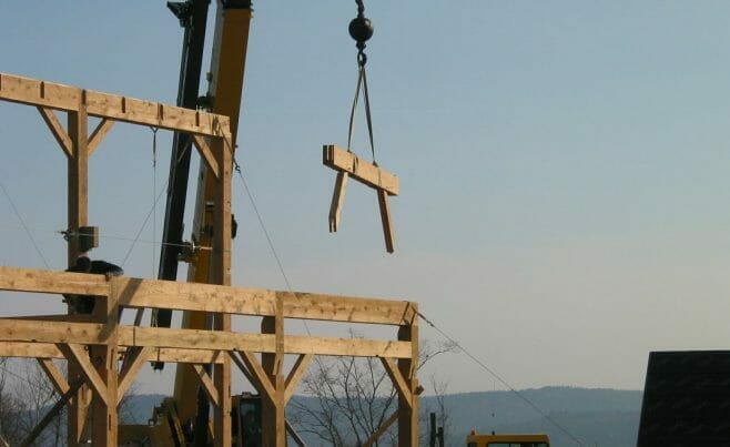 Heavy Timber connector is being swung into place with a crane