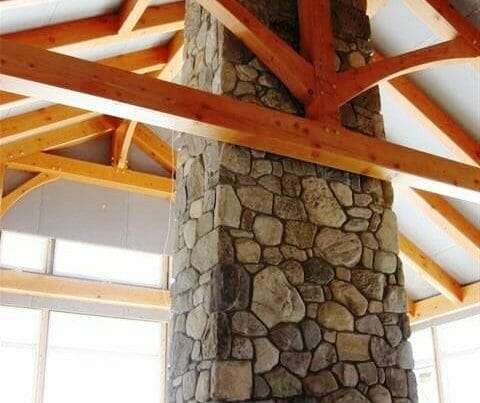 King post truss by a field stone fireplace.