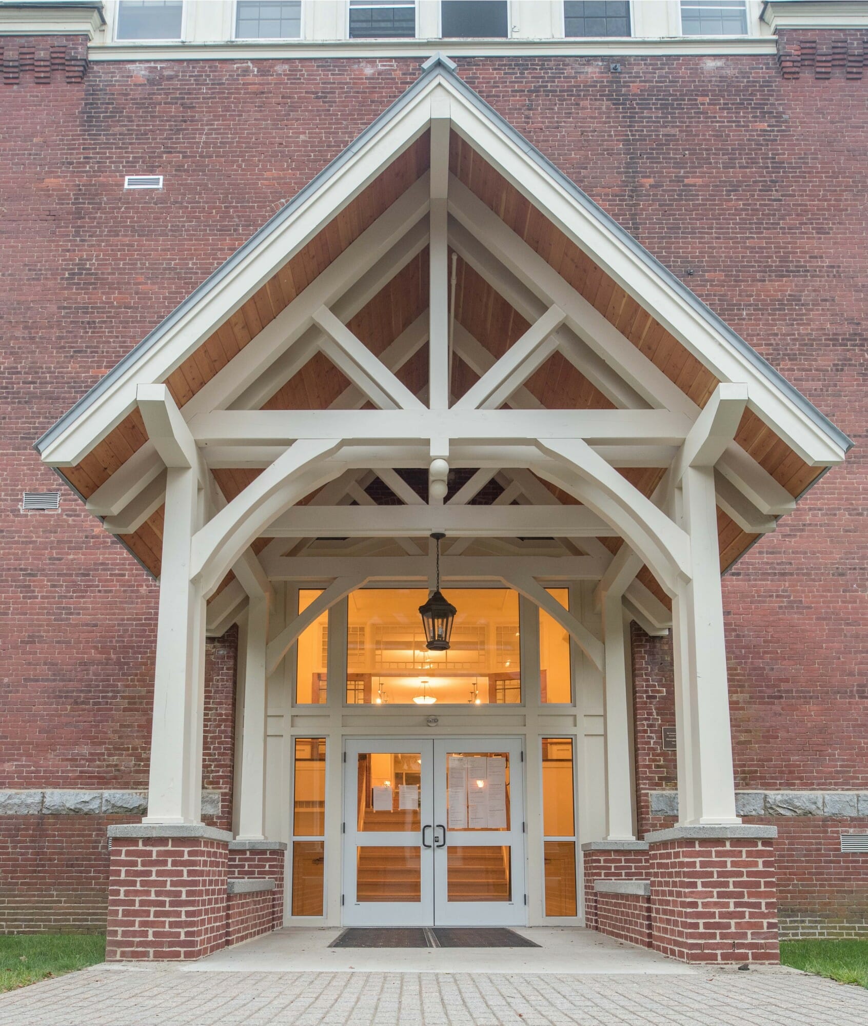 White Entry Canopy with king post trusses at Fuller Hall at the Vermont Academy school made with douglas fir
