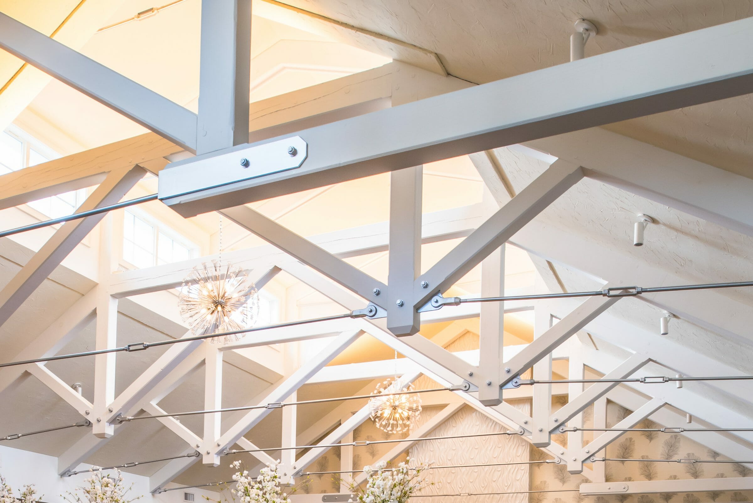 Steel tie bar and steel plate joinery details on a white timber truss in the Anya Restaurant in Thompson, CT.