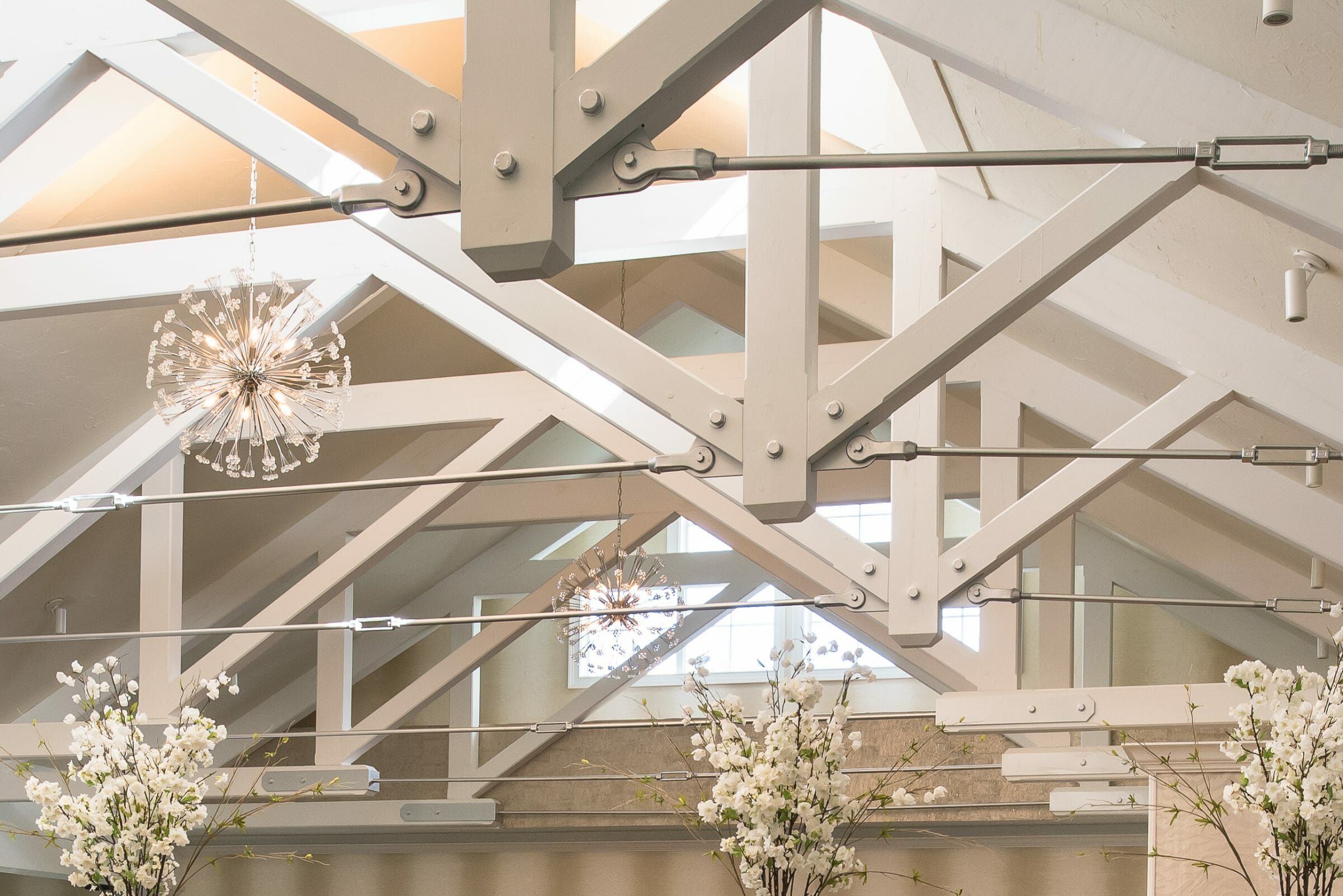 Steel tie bar and steel plate joinery details on a white timber truss in the Anya Restaurant in Thompson, CT.