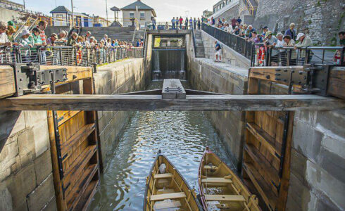 Two replica canal boats entering a timber framed lock