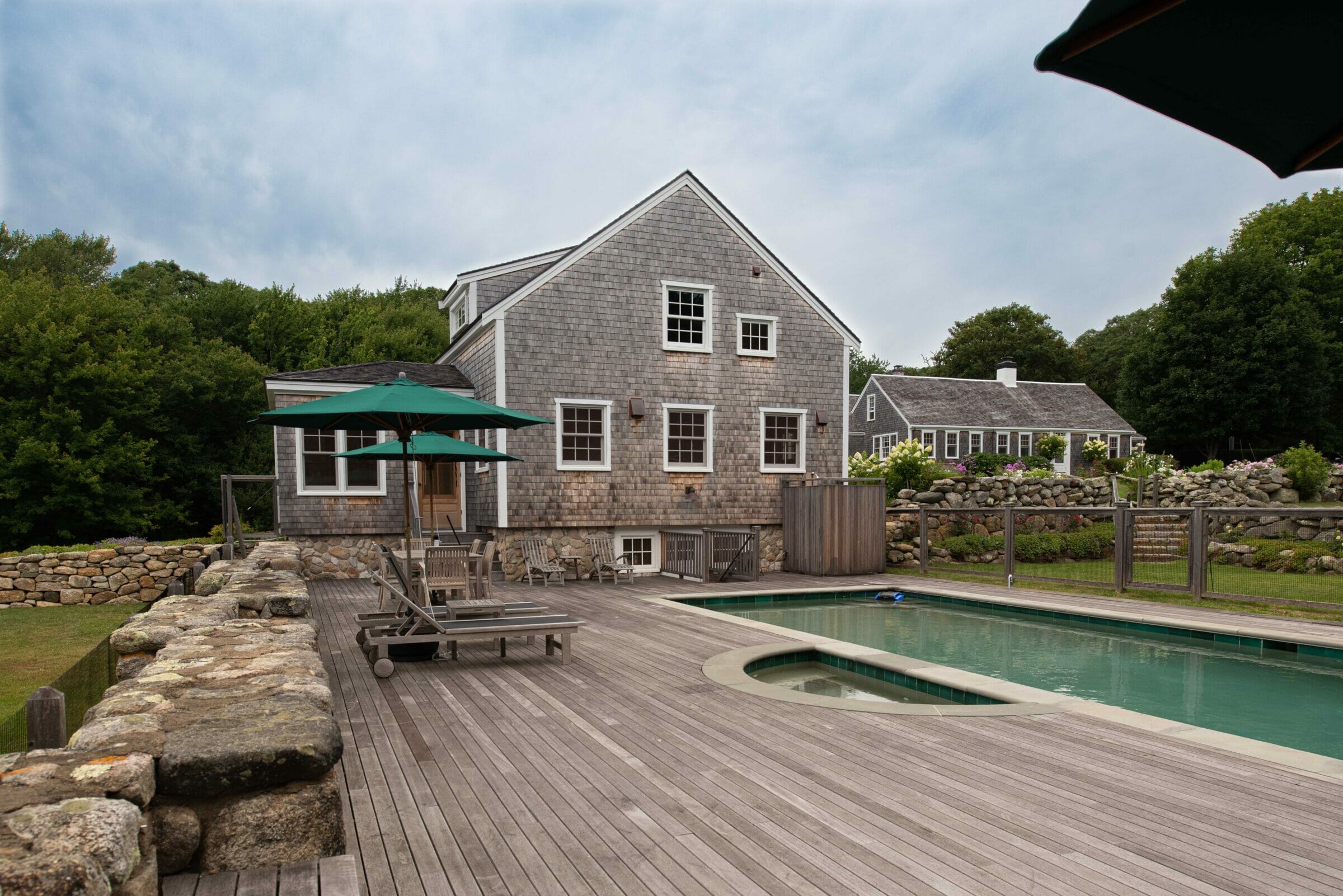 Exterior of a Guest Cottage Beach House in Martha's Vineyard overlooking the pool with traditional weathered Cedar siding