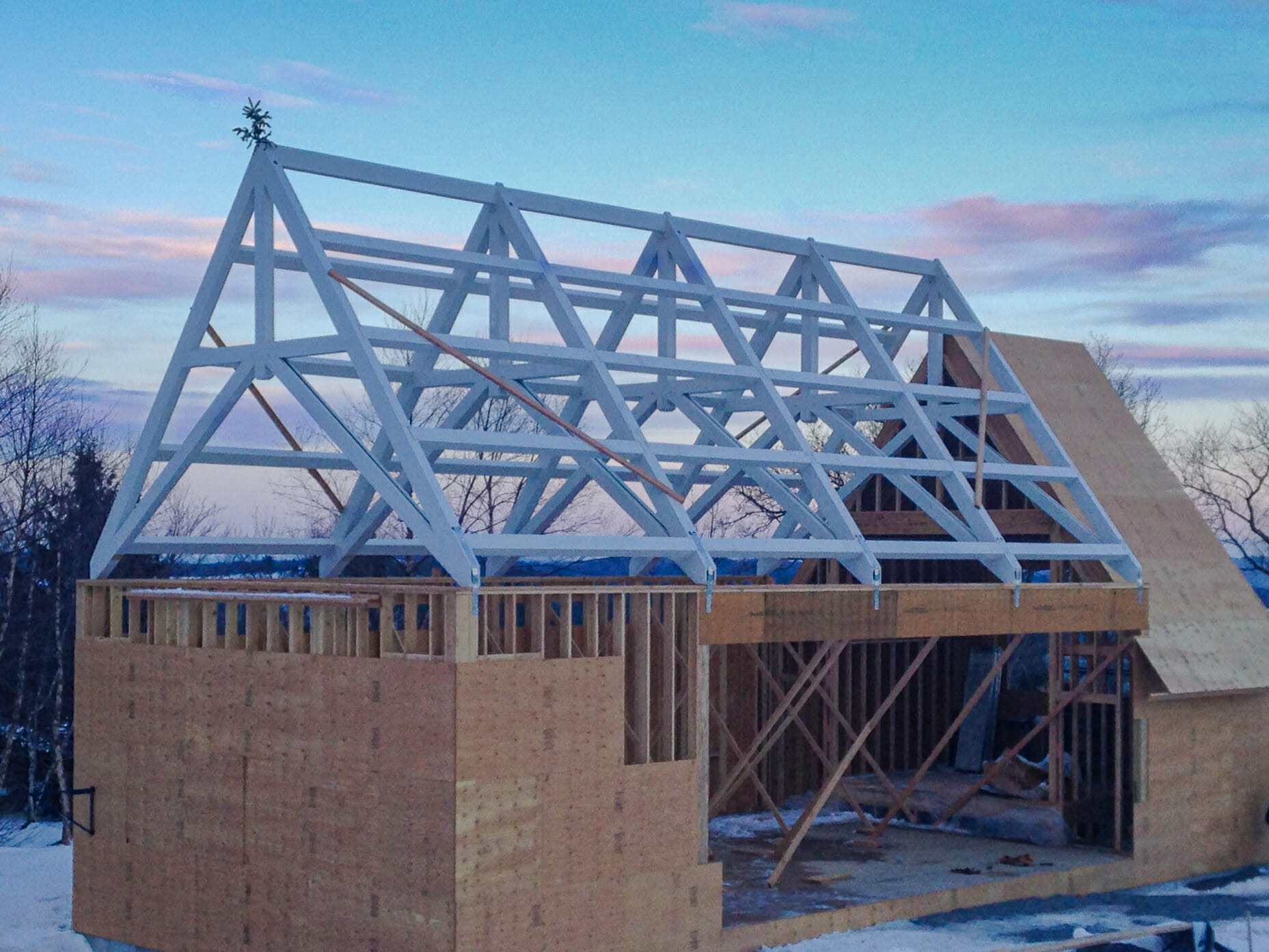 Scissor trusses with a dramatic pitch that have been stained white for a private chapel/pool building