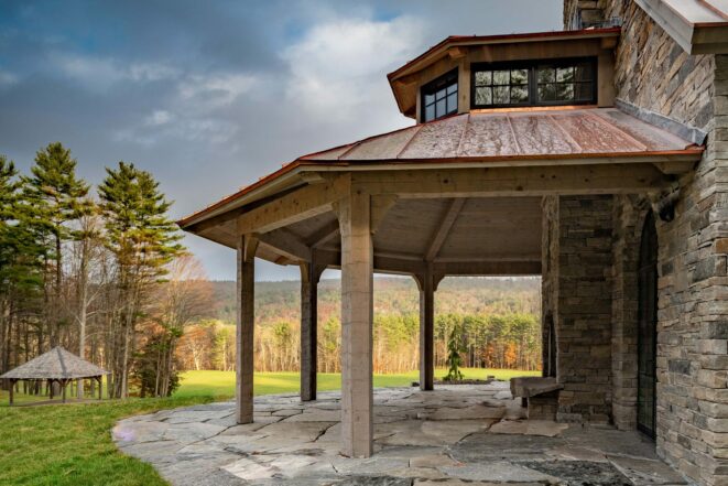 Exterior of a home in New Hampshire with a Hand Hewn Timber Framed Loggia or attached outdoor entertainment area