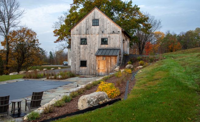 Two story post and beam bank barn with gardens.