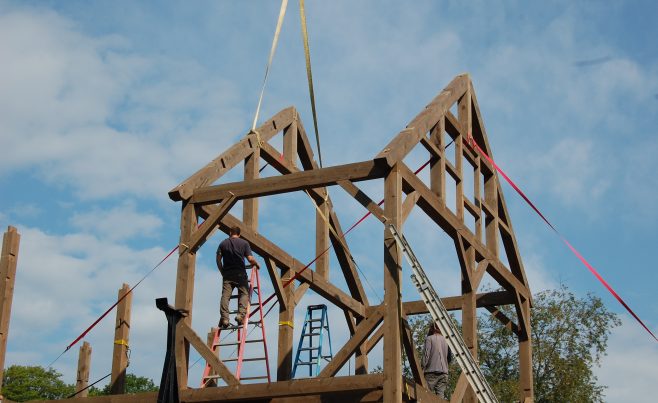 Post and Beam Timber Frame being erected and stabilized with nylon straps