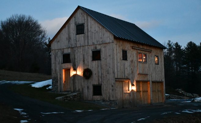 Exterior of timber frame bank barn at night with soft accent lights