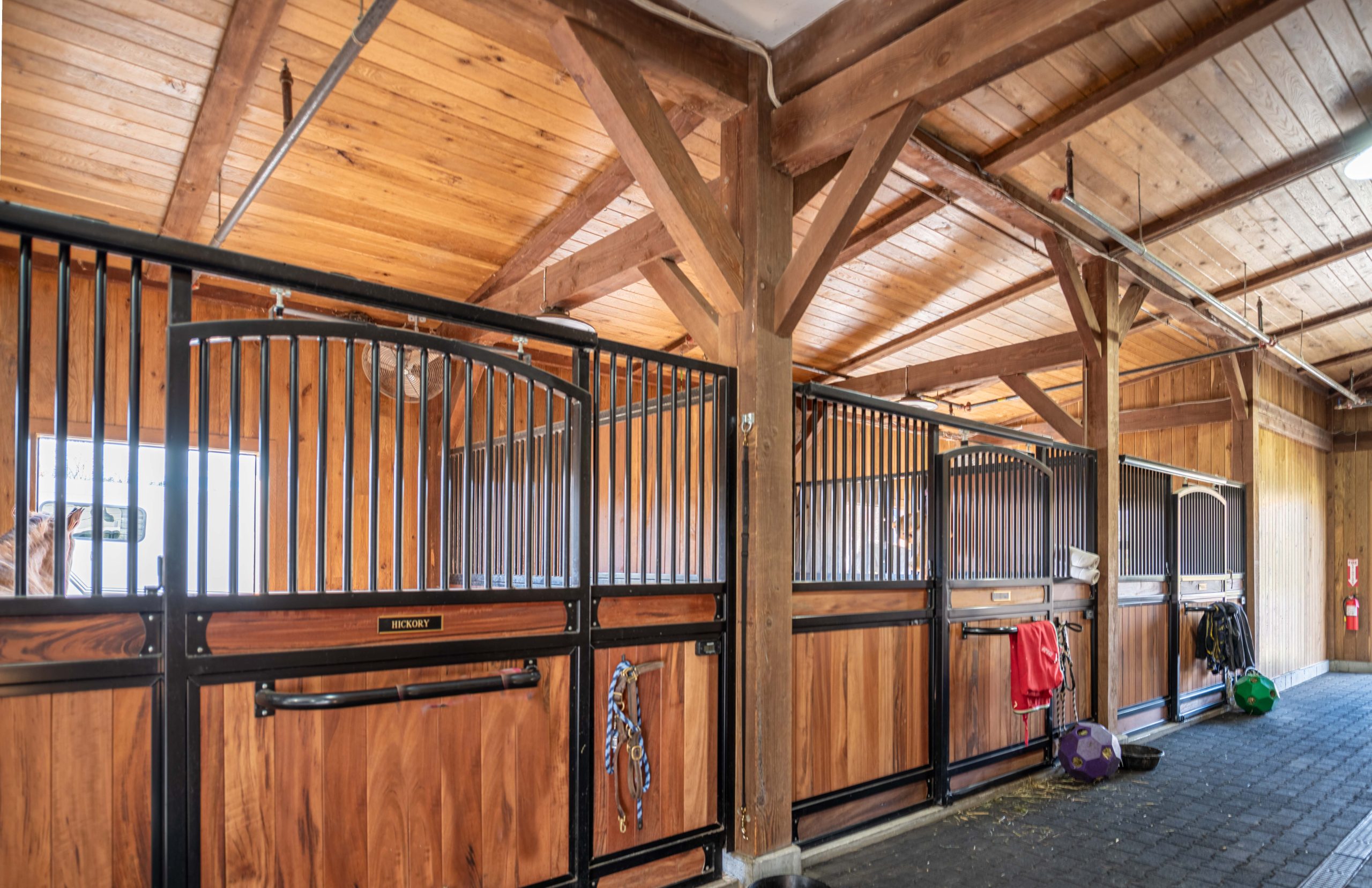 Custom stall hardware in a post and beam horse barn