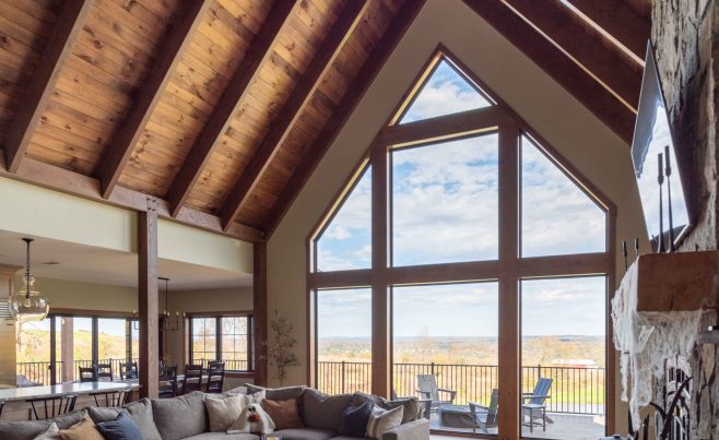 Post and beam living room with a cathedral ceiling window wall.