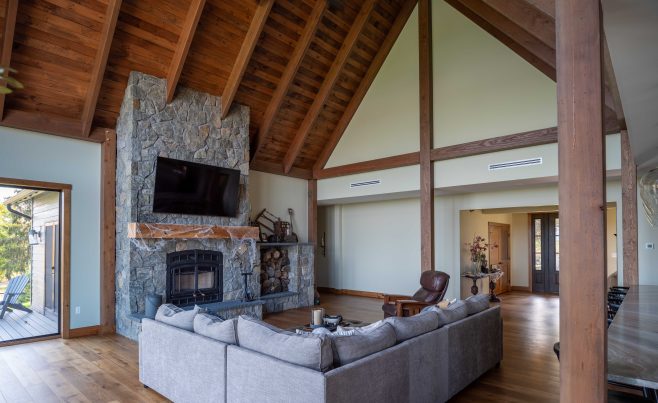Stone fireplace in a living room with post and beam rafters
