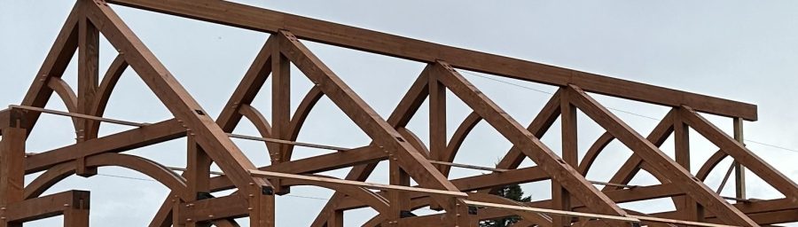 Arched timber trusses space 12 feet apart.