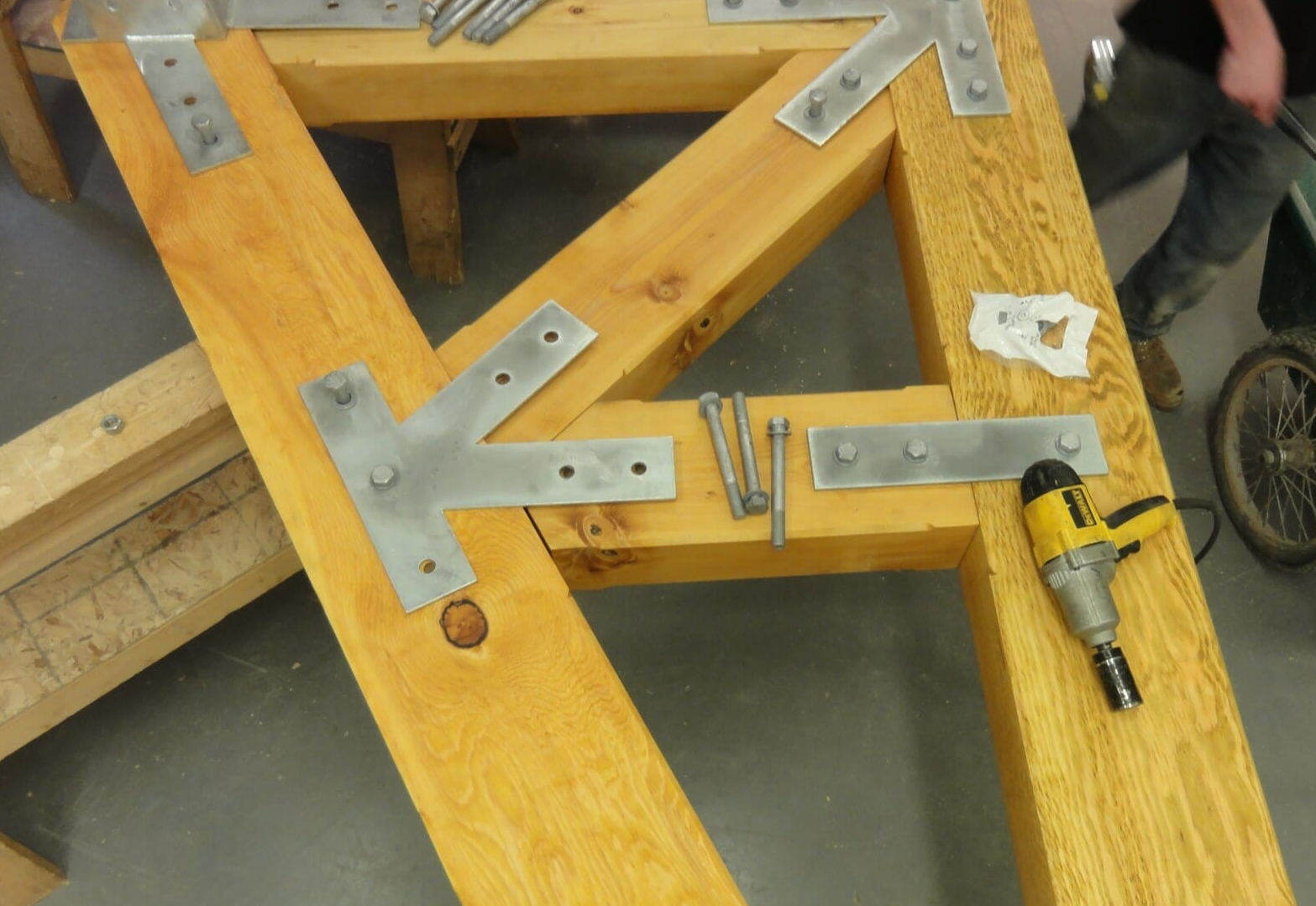Steel gusset plates being fitted to a timber truss